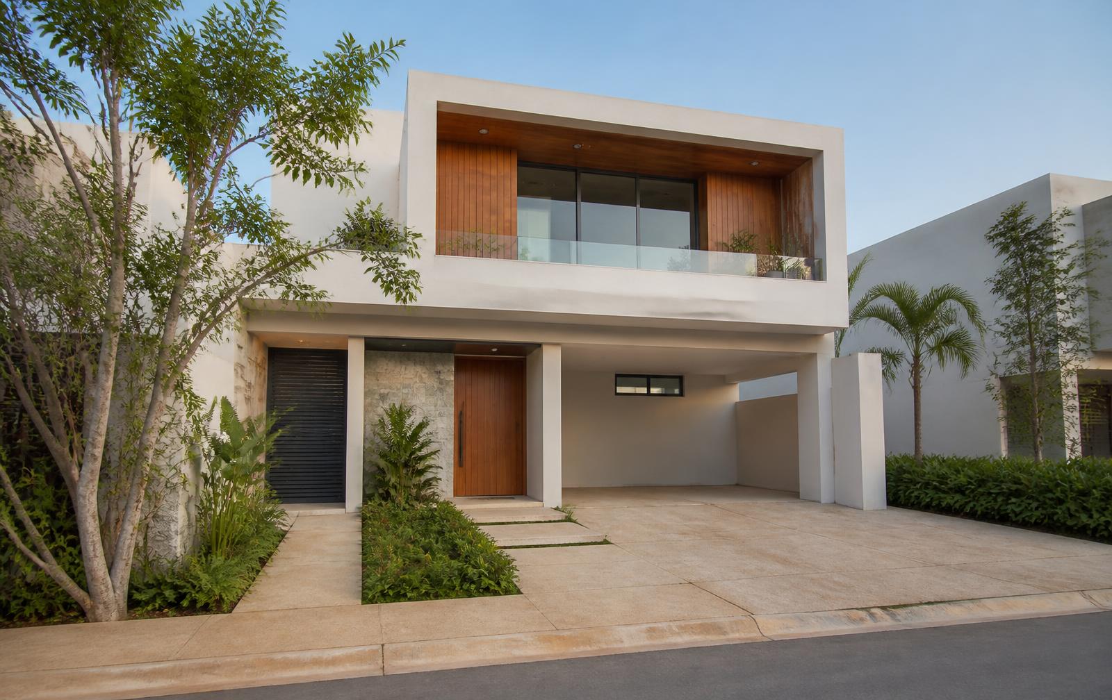 Fachada de una vivienda residencial contemporánea con jardín y acceso amplio